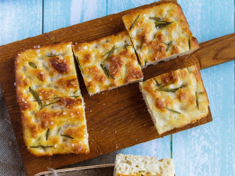 Focaccia aus dem Airfryer auf einem Holzbrett in der Draufsicht.