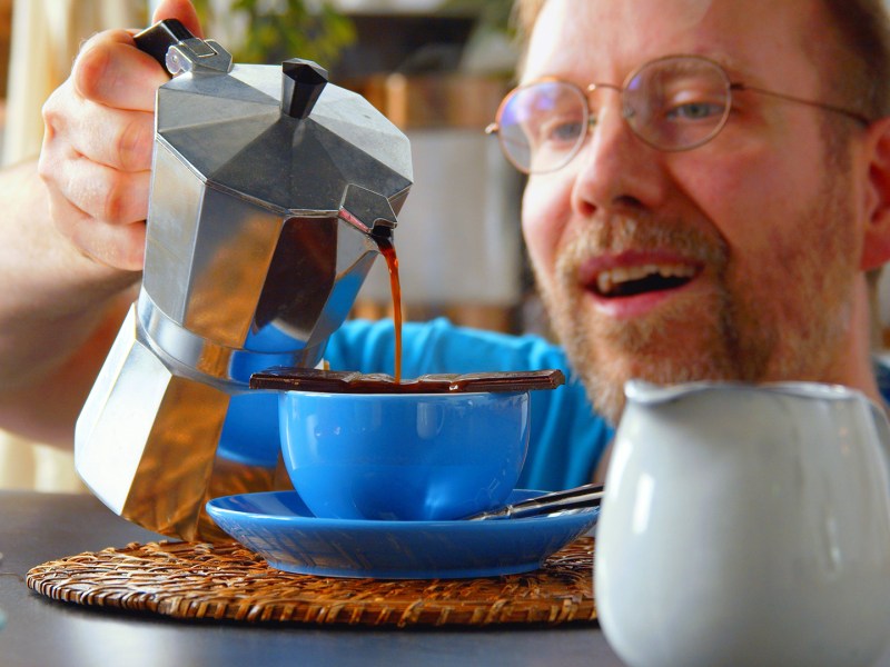 Kaffee-Panna-Cotta: Ein Koch gießt einen Espresso über ein Stück Schokolade.