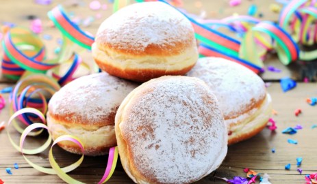 Rezept für Berliner: Mehrere Berliner mit Orangencreme sind übereinander gestapelt. Drumherum liegt Partydeko.