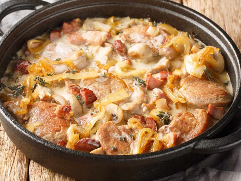 Pfanne mit Schweinefilet mit karamellisierten Zwiebeln und Speck