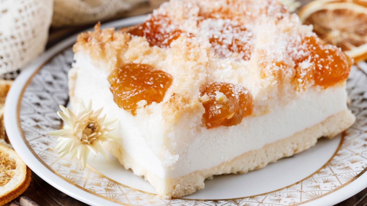Ein Stück Aprikosen-Quarkschnitte mit Kokos auf einem Teller.