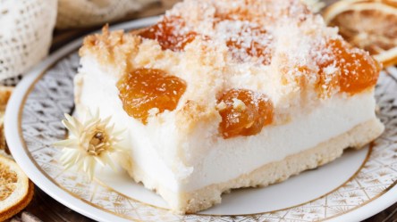 Ein Stück Aprikosen-Quarkschnitte mit Kokos auf einem Teller.