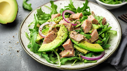 Avocado-Thunfisch-Salat auf einem hellen Teller, garniert mit schwarzem Pfeffer.