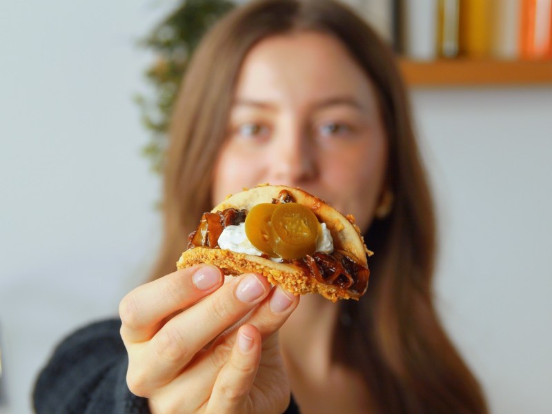 Eine Frau hält einen Taco hoch, indem Bananenschalen verwertet wurden.