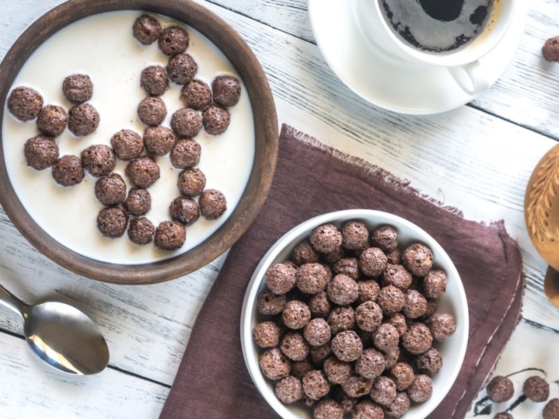 Zwei Schüsseln mit Choco Pops, in einer ist zusätzlich Milch. In der Draufsicht.