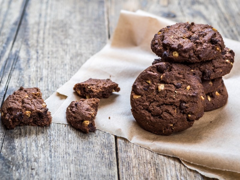 Ein paar Chocolate Chip Cookies mit dreierlei Schokolade auf einer Stoffserviette.