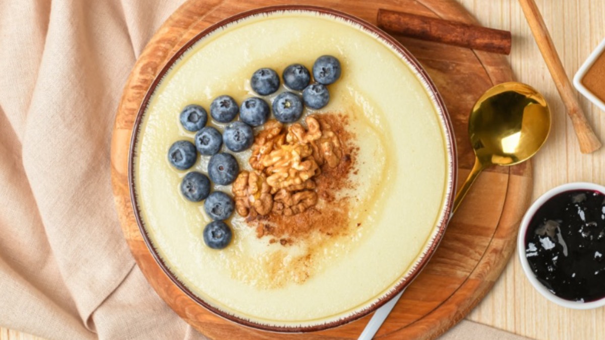 Eine Schüssel Polenta-Grießbrei mit Heidelbeeren, Walnüssen und Zimt in der Schüssel in der Draufsicht.