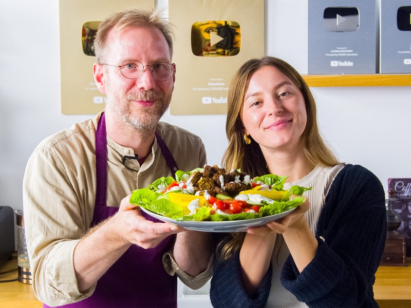 Oli und Adrianna halten eine Falafel-Bowl in die Kamera.
