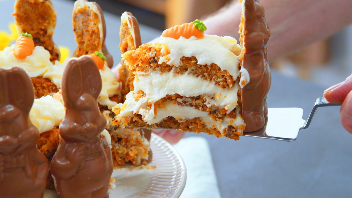 Ein Kochen eninimmt ein Stück Osterhasen-Torte mit Schokohasen.