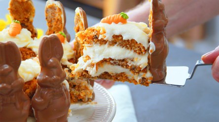 Ein Kochen eninimmt ein Stück Osterhasen-Torte mit Schokohasen.