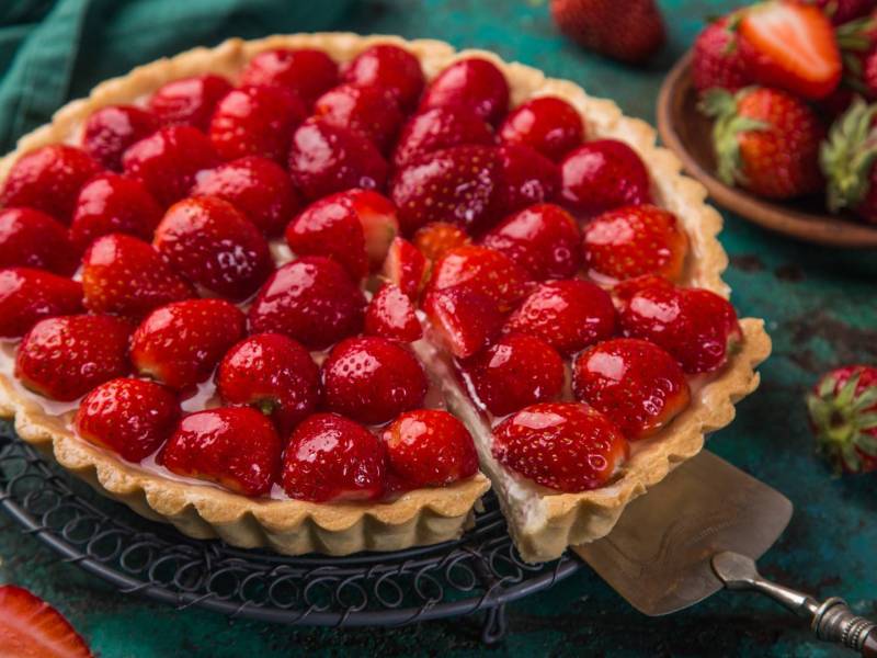 Eine französische Erdbeer-Tarte, von der ein Stock abgeschnitten wurde.