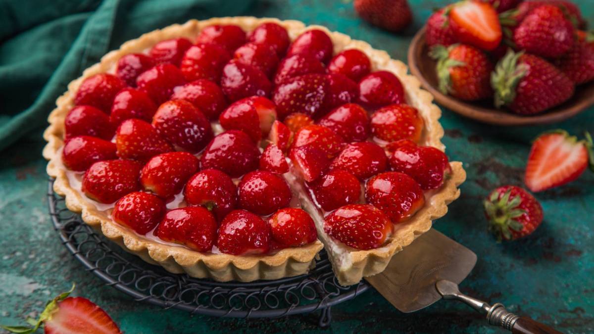 Eine französische Erdbeer-Tarte, von der ein Stock abgeschnitten wurde.