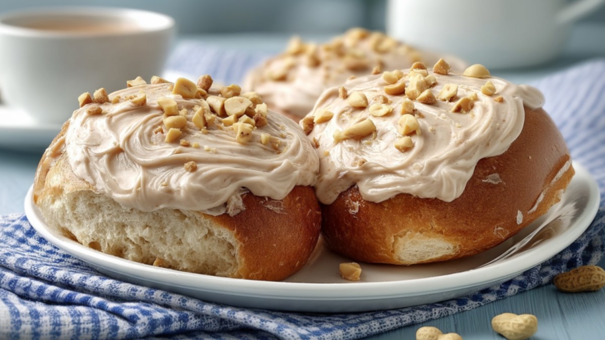 Zwei halbe Brötchen, mit Schoko-Erdnusscreme bestrichen, auf einem Teller.