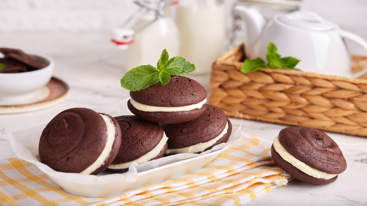 mehrere Whoopie Pies auf einem Tellerm drumherum etwas Geschirr.