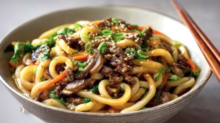 Eine Schüssel mit Bulgogi-Udon-Nudeln. Auf dem Rand liegen Essstäbchen.