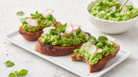 Drei Scheiben Erbsen-Bruschetta auf einem Teller.