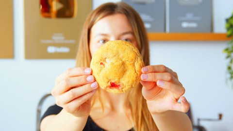 Gefüllte Erdbeer-Cheesecake-Cookies: Eine Köchin hält einen Keks in die Kamera.