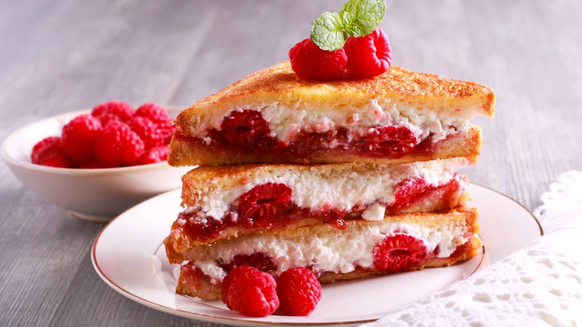 Ein Stapel gefüllter French Toast mit Ricotta und Himbeeren.
