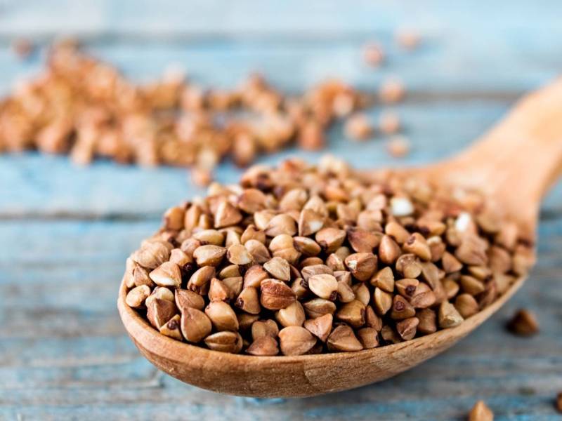 Ist Buchweizen gesund? Buchweizenkörner auf einem Holzlöffel.