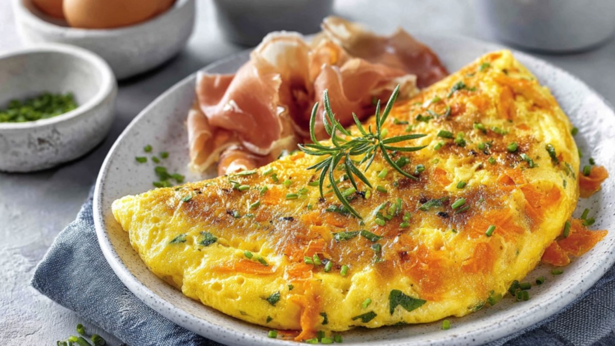 Ein Karotten-Omelett mit Schinken auf einem Teller.