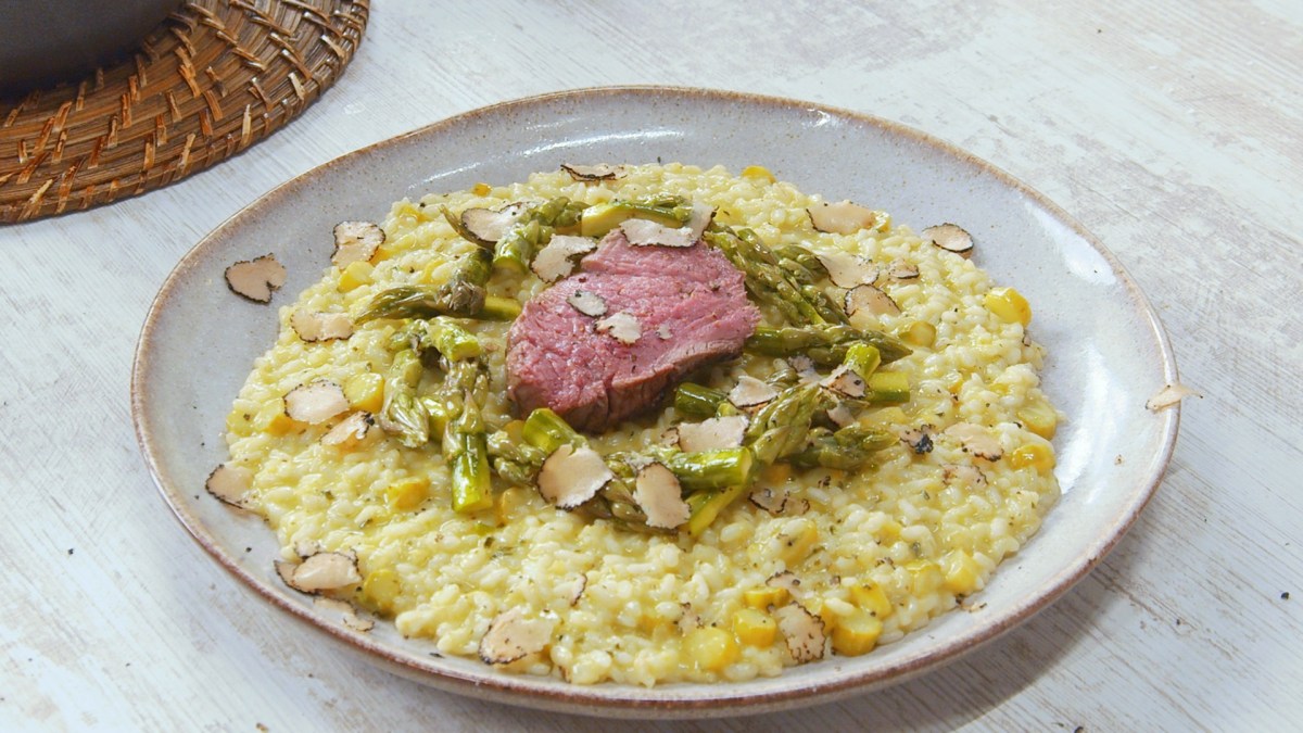 Spargelrisotto mit Rinderfilet auf einem Teller.