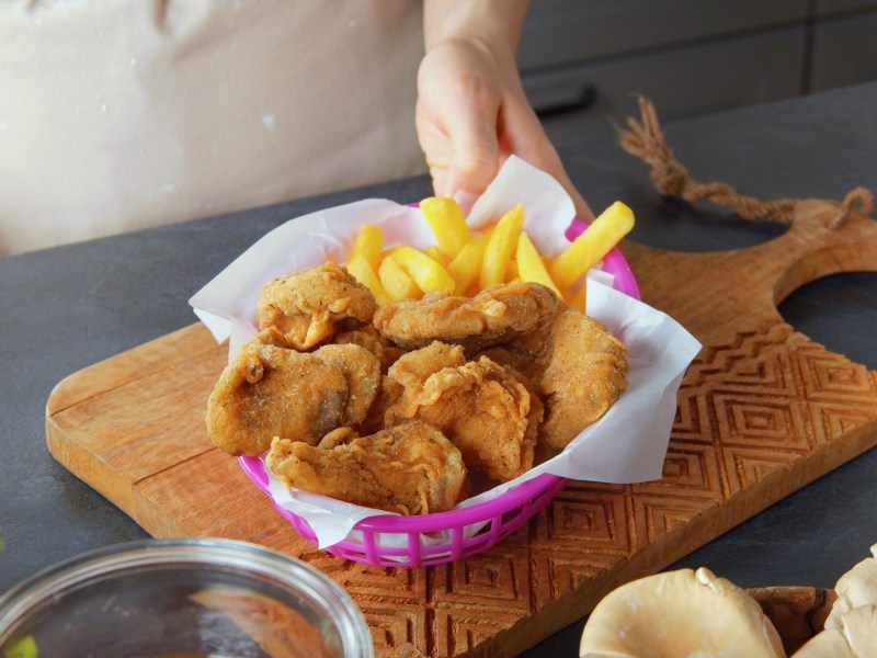 Frittierte Austernpilze mit Pommes in einer Schale.