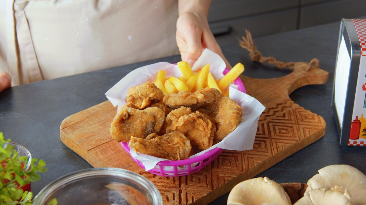 Frittierte Austernpilze mit Pommes in einer Schale.