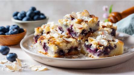 Teller mit Stücken von Heidelbeer-Buttermilchkuchen mit Kokos-Mandel-Kruste