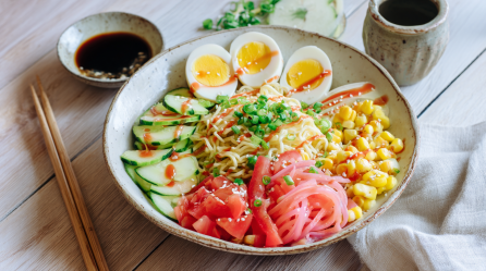Eine Schüssel mit Hiyashi-Chuka. Links neben der Schüssel liegen Stäbchen sowie eine Schlae Sojasoße.