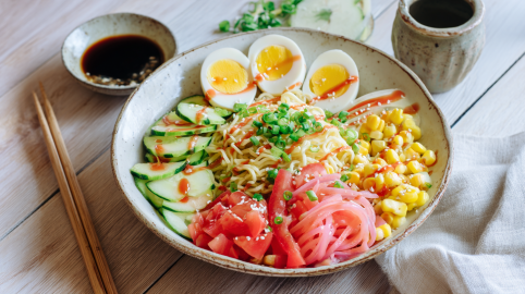 Eine Schüssel mit Hiyashi-Chuka. Links neben der Schüssel liegen Stäbchen sowie eine Schlae Sojasoße.