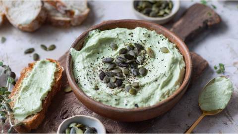 Schale mit Kürbiskern-Quark-Aufstrich und Brot daneben