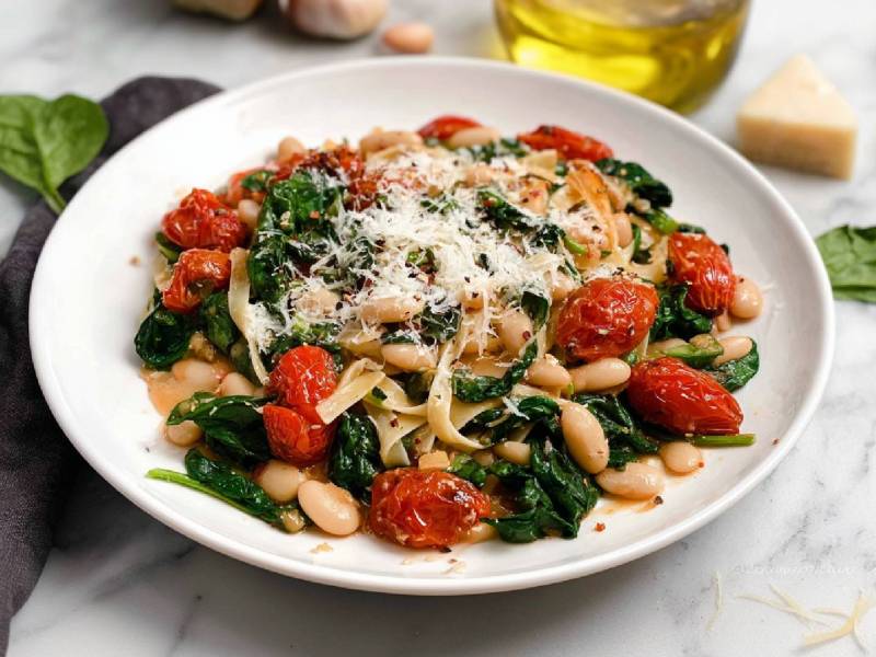 Teller Nudeln mit weißen Bohnen, Parmesan, Spinat und Tomaten