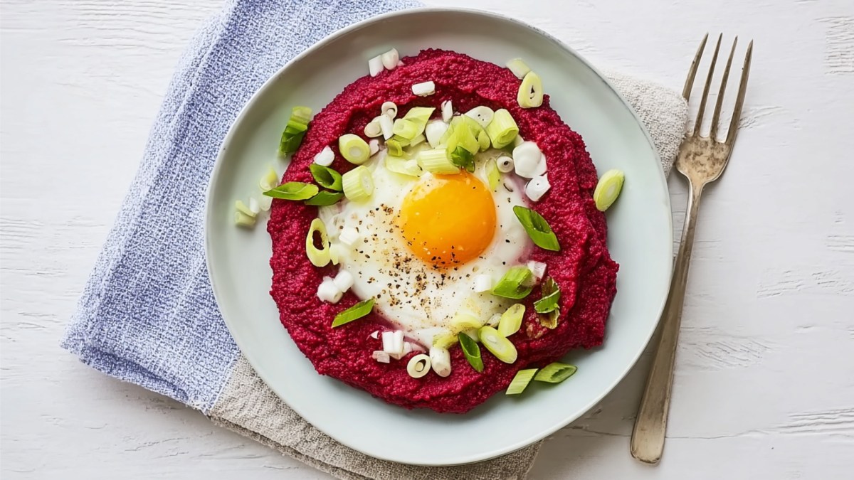 Rote-Bete-Püree mit Spiegelei auf einem Teller in der Draufsicht.