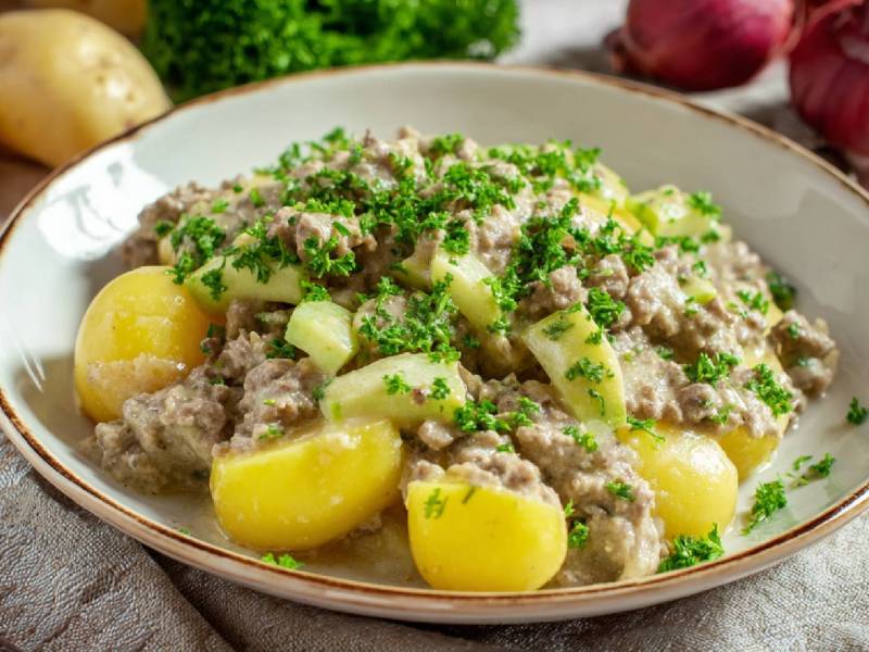 Teller mit Schmorgurken-Hackfleisch-Pfanne und Kartoffeln