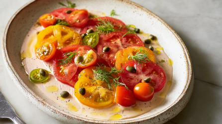 Ein Teller Tomato Tonnato, serviert mit Kapern und Fenchelgrün.