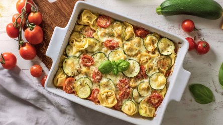 Ein Tortellini-Auflauf mit Zucchini und Tomaten in der Draufsicht.