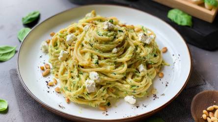 Teller mit Nudeln in Zucchini-Feta-Soße