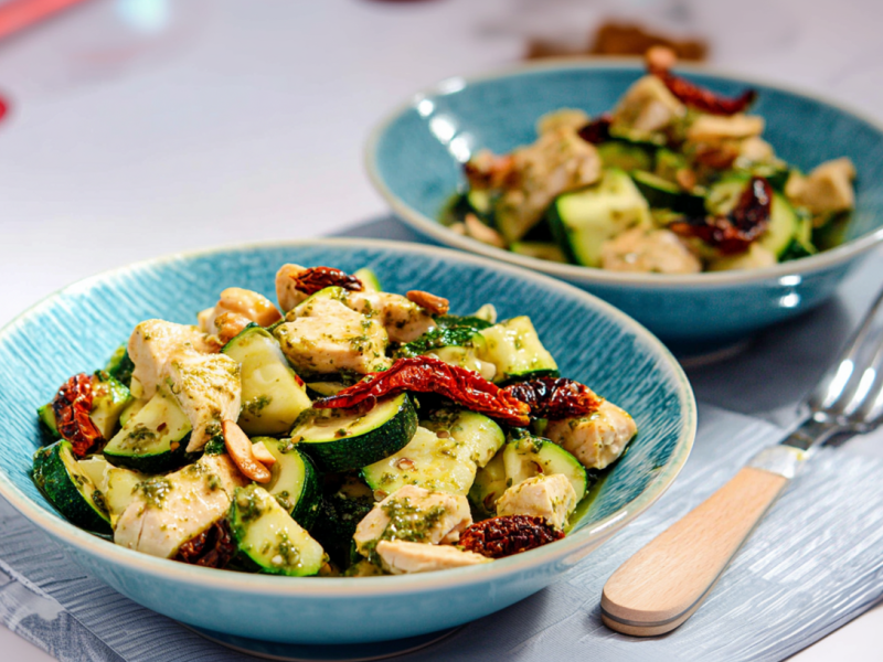 Zucchini-Hähnchen-Salat, serviert in zwei Schalen. Daneben liegt eine Gabel.