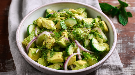 Eine Schale Avocado-Gurkensalat mit roten Zwiebeln.