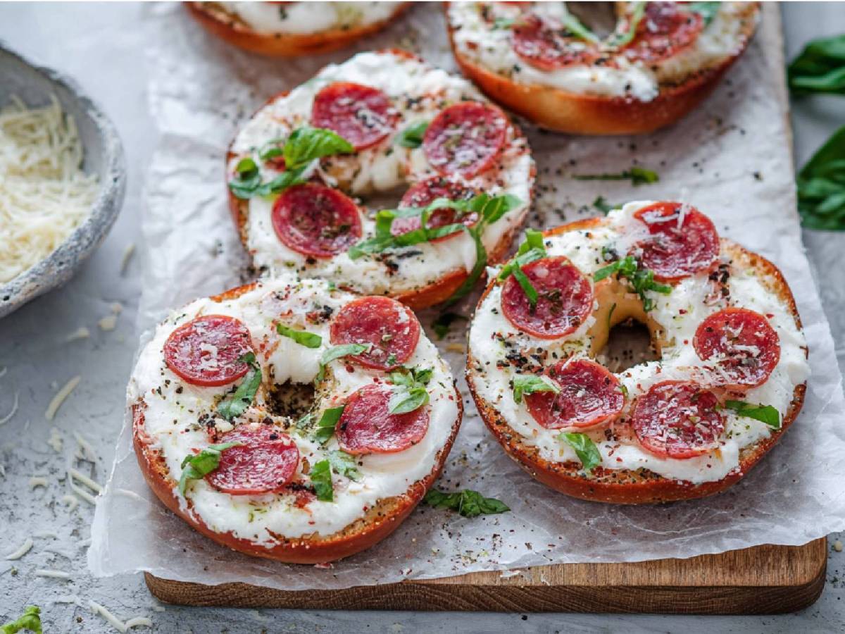 Holzbrett mit 5 Bagel-Pizzen