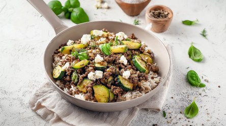 Eine Hackfleischpfanne mit Zucchini, Feta und Reis.