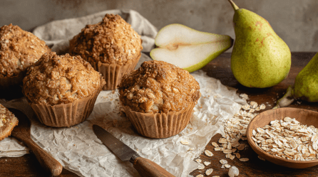 Haferflocken-Birnen-Muffins auf einer Backpapier-Unterlage.