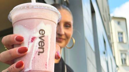 Redakteurin Nina hält einen Erdbeer-Smoothie, der Hailey Bieber's Strawberry Glaze Skin Smoothie ähnelt in die Kamera.