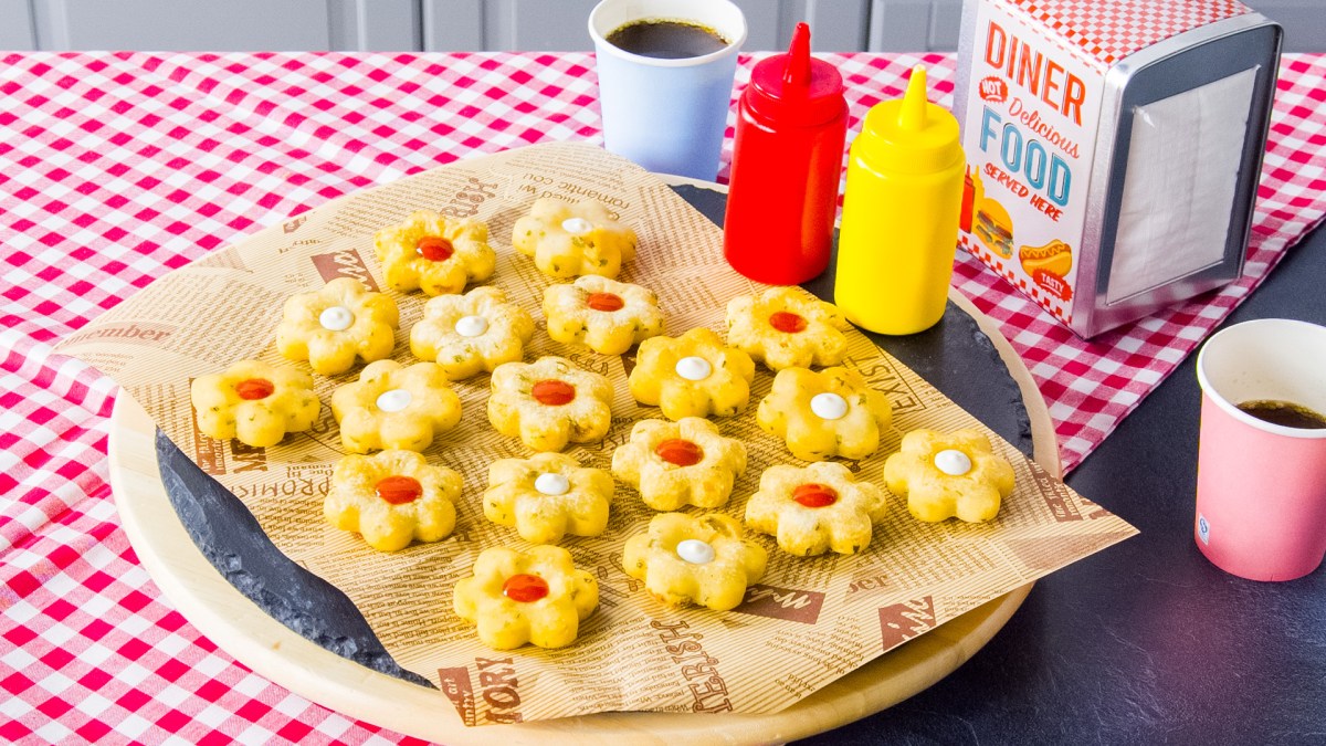 Knusprige Kartoffelblumen mit Ketchup und Mayo auf einem Teller.
