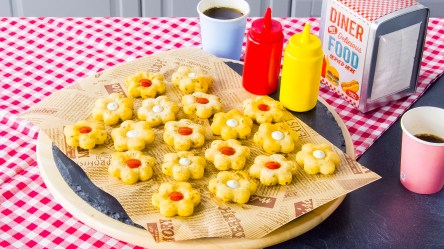 Knusprige Kartoffelblumen mit Ketchup und Mayo auf einem Teller.