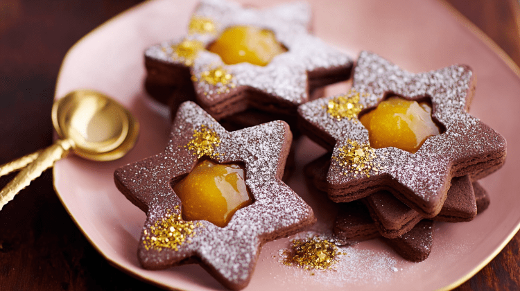 Schoko-Orangen-Sterne liegen auf einem Teller, zwei kleine Löffel daneben.
