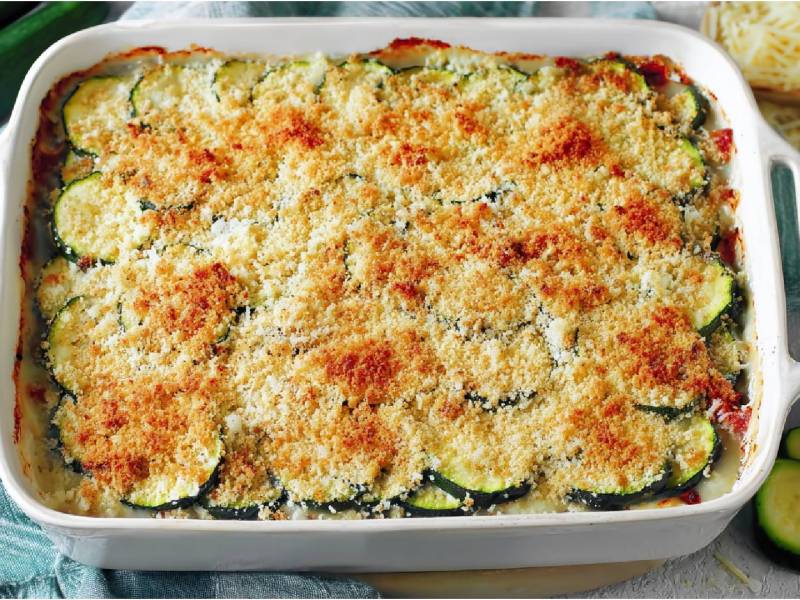 Auflaufform mit Zucchini-Gratin mit Béchamelsoße und Panko-Parmesanhaube