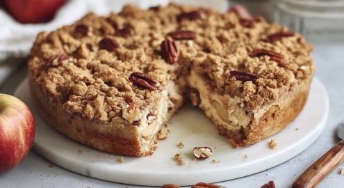 Ein angeschnittener Apfel-Pekannuss-Kuchen mit Streuseln.