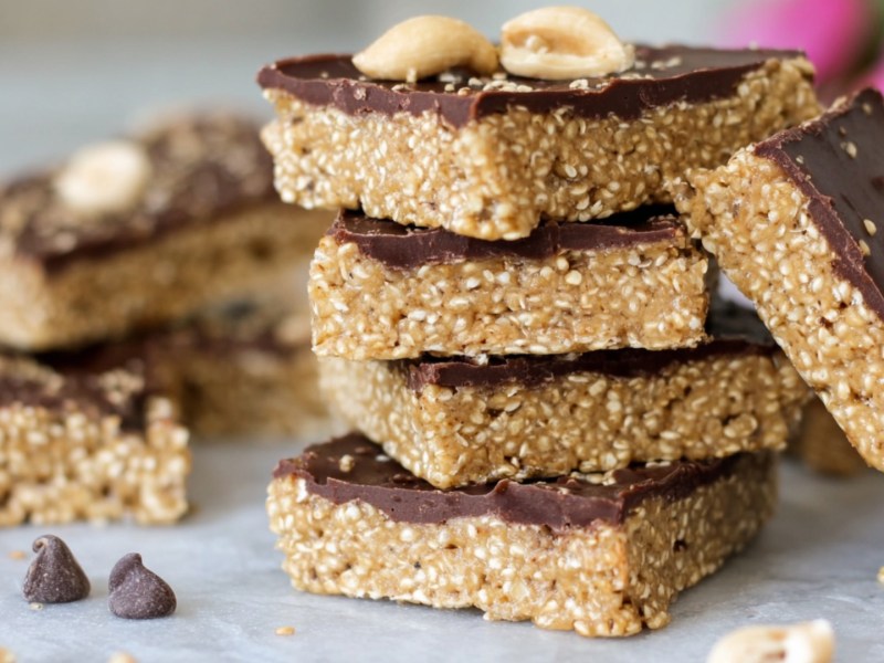 Mehrere übereinander gestapelte Erdnussbutter-Quinoa-Riegel.