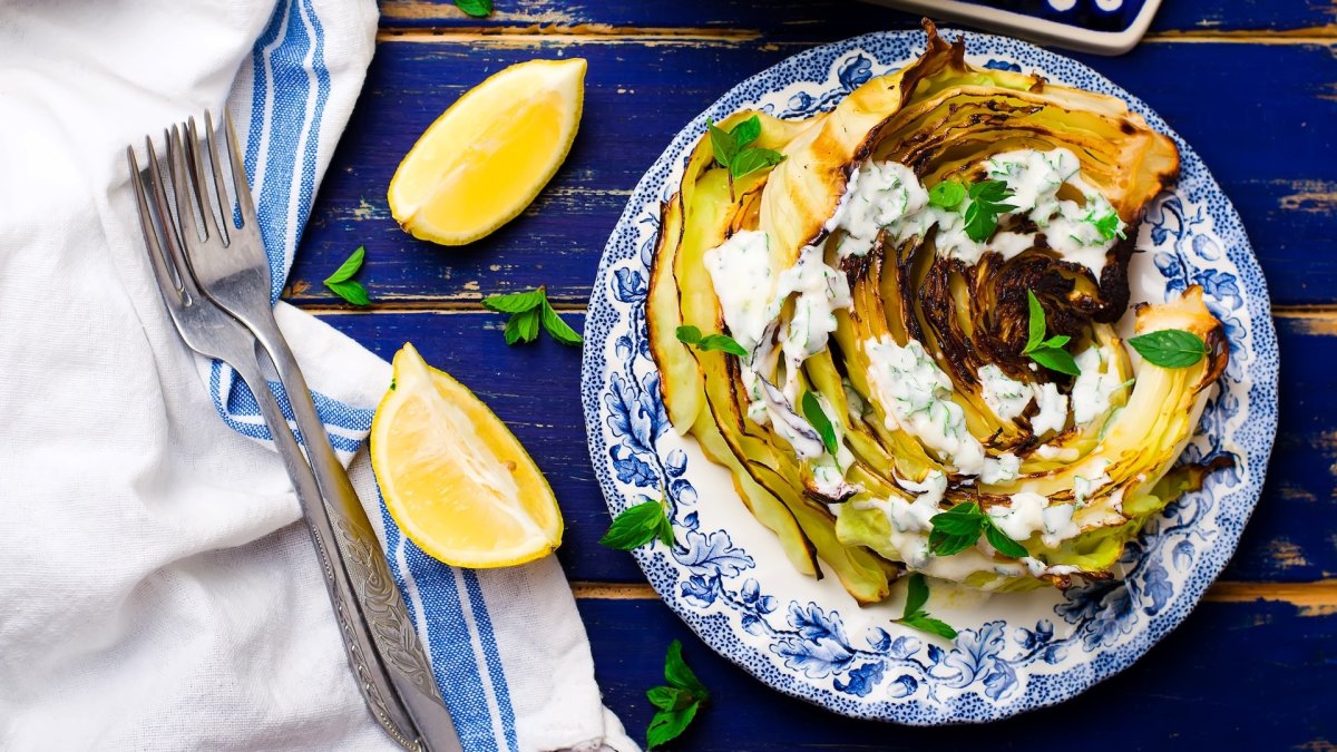 Gebratener Spitzkohl mit Walnusscreme auf einem blau-weiß gemusterten Teller.